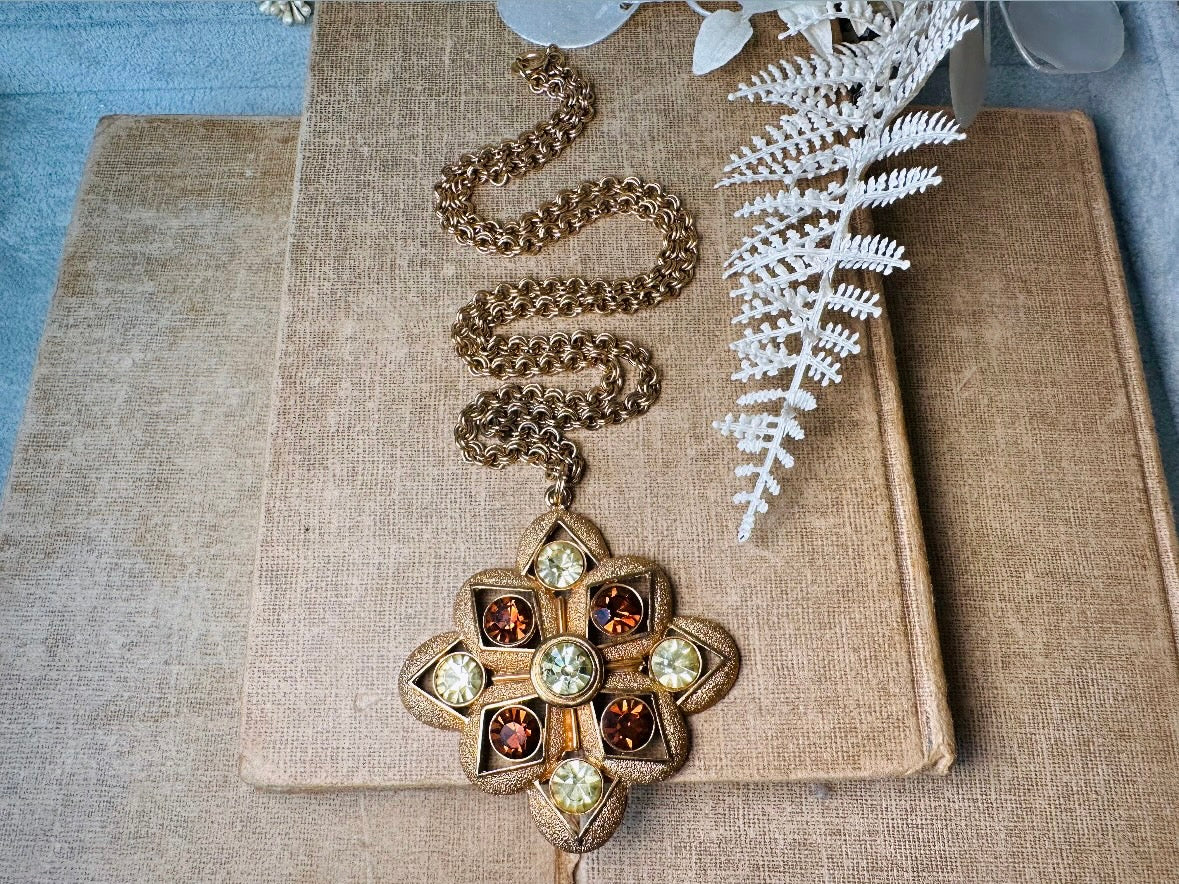 This 1970s vintage gold maltese cross pendant necklace is absolutely stunning! Featuring shimmering crystals in topaz and citrine set in a textured gold Etruscan pendant. This large bold vintage pendant is suspended from its original double link gold rolo chain, that fastens with a spring ring clasp. Signed SC from 1975.