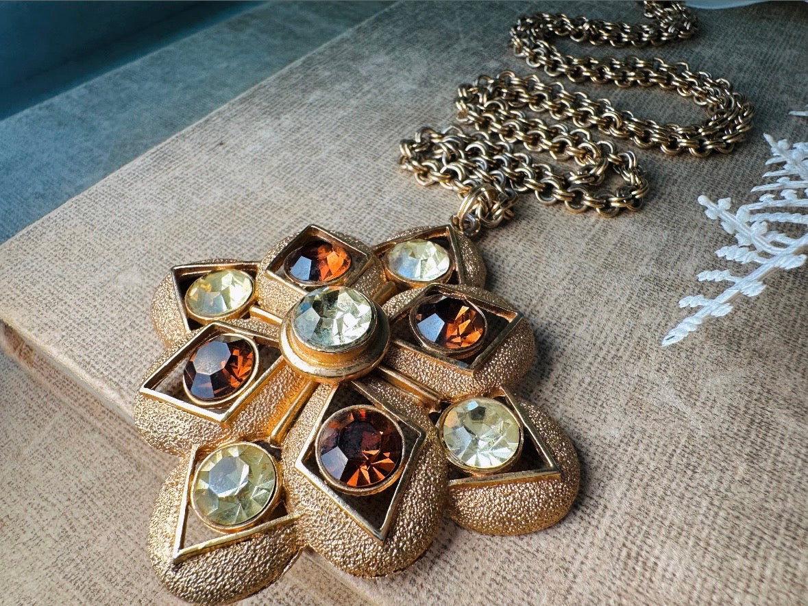 This 1970s vintage gold maltese cross pendant necklace is absolutely stunning! Featuring shimmering crystals in topaz and citrine set in a textured gold Etruscan pendant. This large bold vintage pendant is suspended from its original double link gold rolo chain, that fastens with a spring ring clasp. Signed SC from 1975.