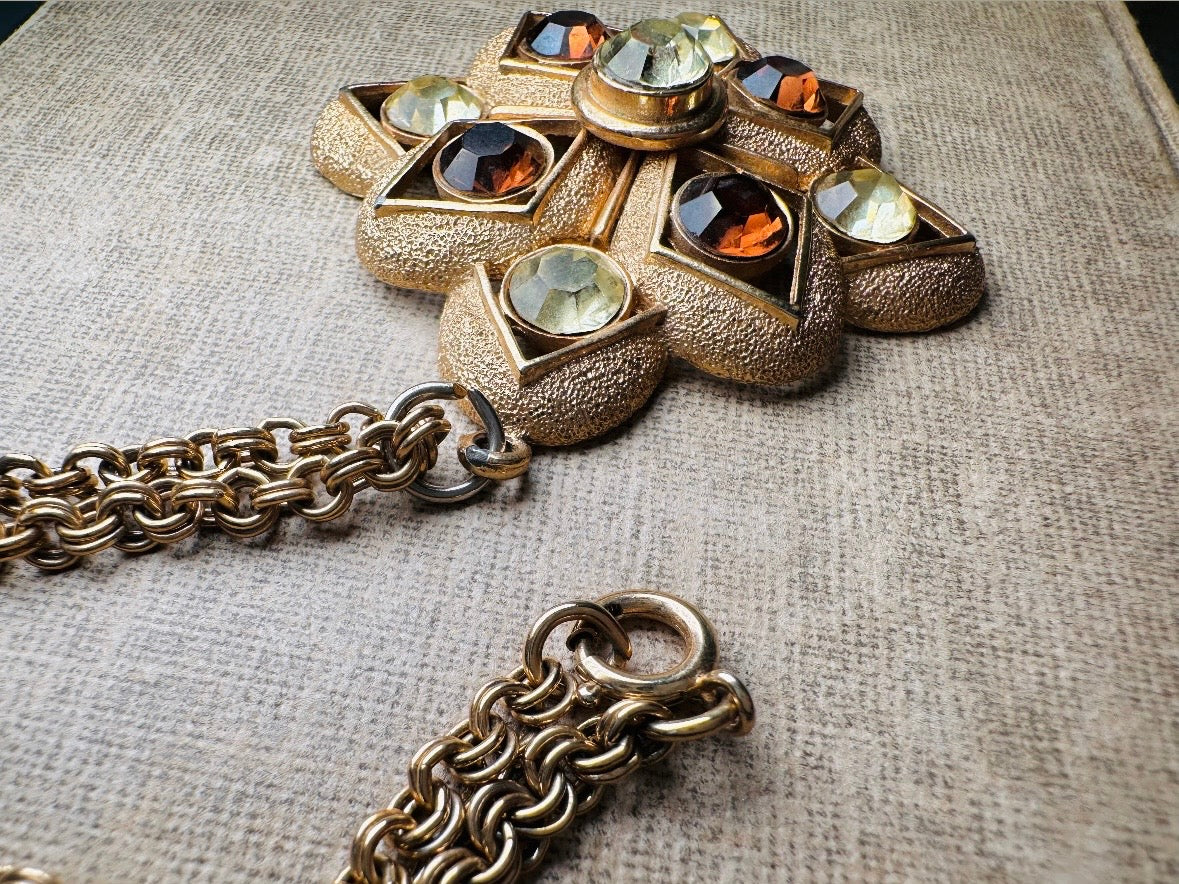 This 1970s vintage gold maltese cross pendant necklace is absolutely stunning! Featuring shimmering crystals in topaz and citrine set in a textured gold Etruscan pendant. This large bold vintage pendant is suspended from its original double link gold rolo chain, that fastens with a spring ring clasp. Signed SC from 1975.