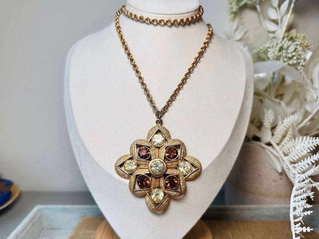 This 1970s vintage gold maltese cross pendant necklace is absolutely stunning! Featuring shimmering crystals in topaz and citrine set in a textured gold Etruscan pendant. This large bold vintage pendant is suspended from its original double link gold rolo chain, that fastens with a spring ring clasp. Signed SC from 1975.