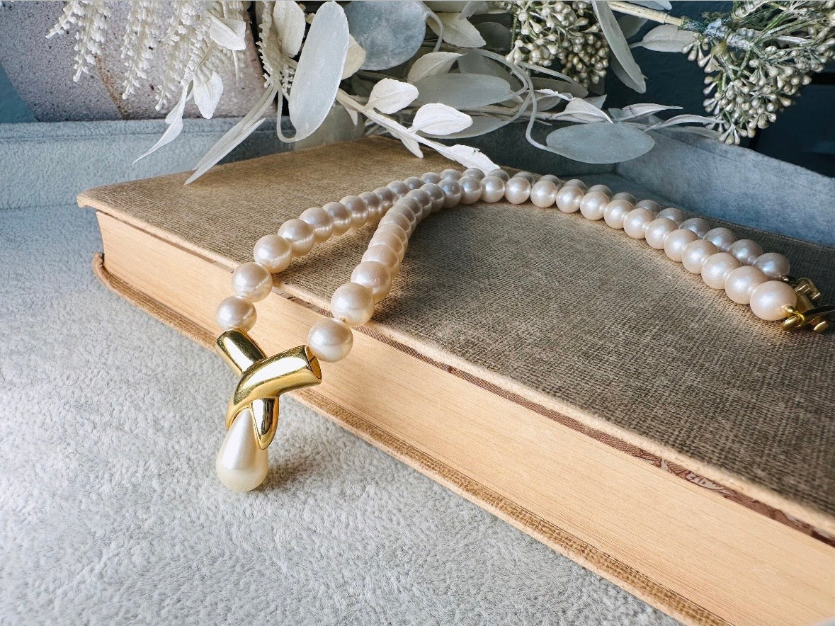 This vintage Napier pearl pendant necklace is stunning. From the 1980s this necklace is sleek and interesting, featuring 8mm cream pearls with a gold twist and cream pearl teardrop pendant. Fold over clasp with Napier signature. Would look beautiful on a bride or stacked with some chains for a modern spin. In excellent vintage condition.