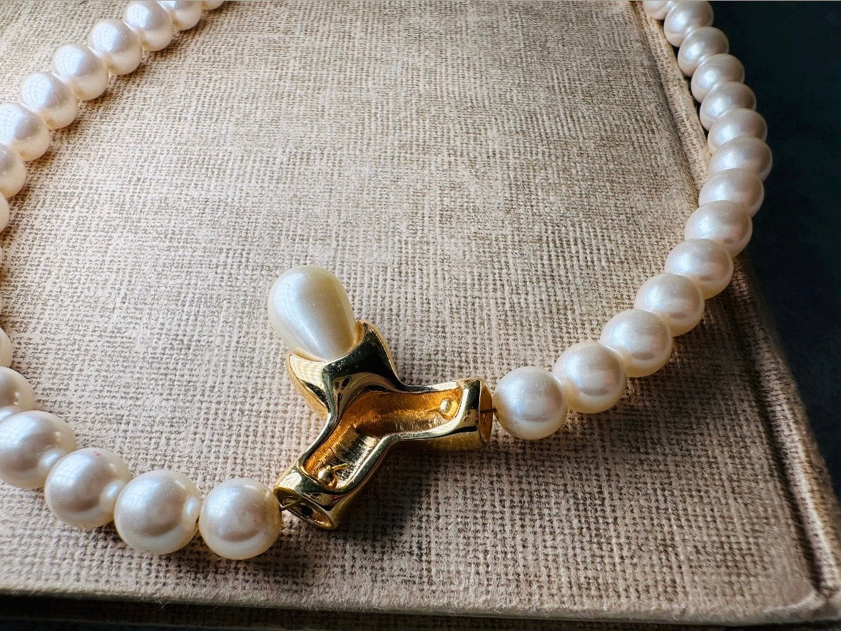This vintage Napier pearl pendant necklace is stunning. From the 1980s this necklace is sleek and interesting, featuring 8mm cream pearls with a gold twist and cream pearl teardrop pendant. Fold over clasp with Napier signature. Would look beautiful on a bride or stacked with some chains for a modern spin. In excellent vintage condition.
