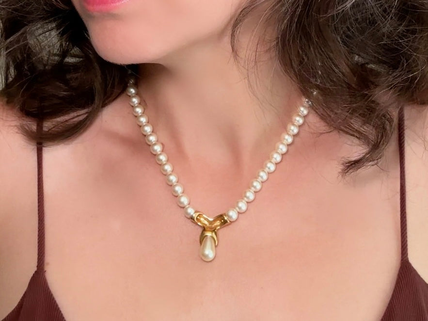 This vintage Napier pearl pendant necklace is stunning. From the 1980s this necklace is sleek and interesting, featuring 8mm cream pearls with a gold twist and cream pearl teardrop pendant. Fold over clasp with Napier signature. Would look beautiful on a bride or stacked with some chains for a modern spin. In excellent vintage condition.