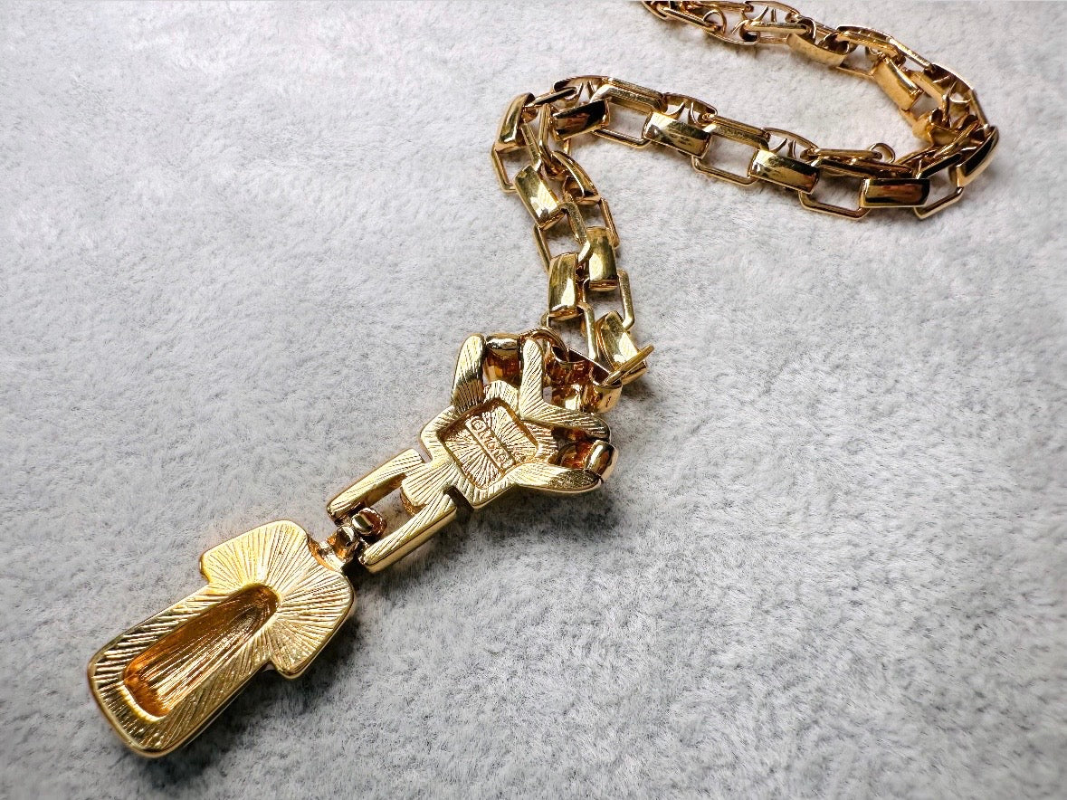 This vintage gold chain Y necklace by Monet is a rare find. Featuring flat link cable chain with a geometric drop pendant with cream enamel accents. This signed vintage necklace is from the 1970s at a peak time for Monet designs. This classic necklace is in excellent condition and just as classic today as it was when it debuted. Adjustable length with a hook closure. 
