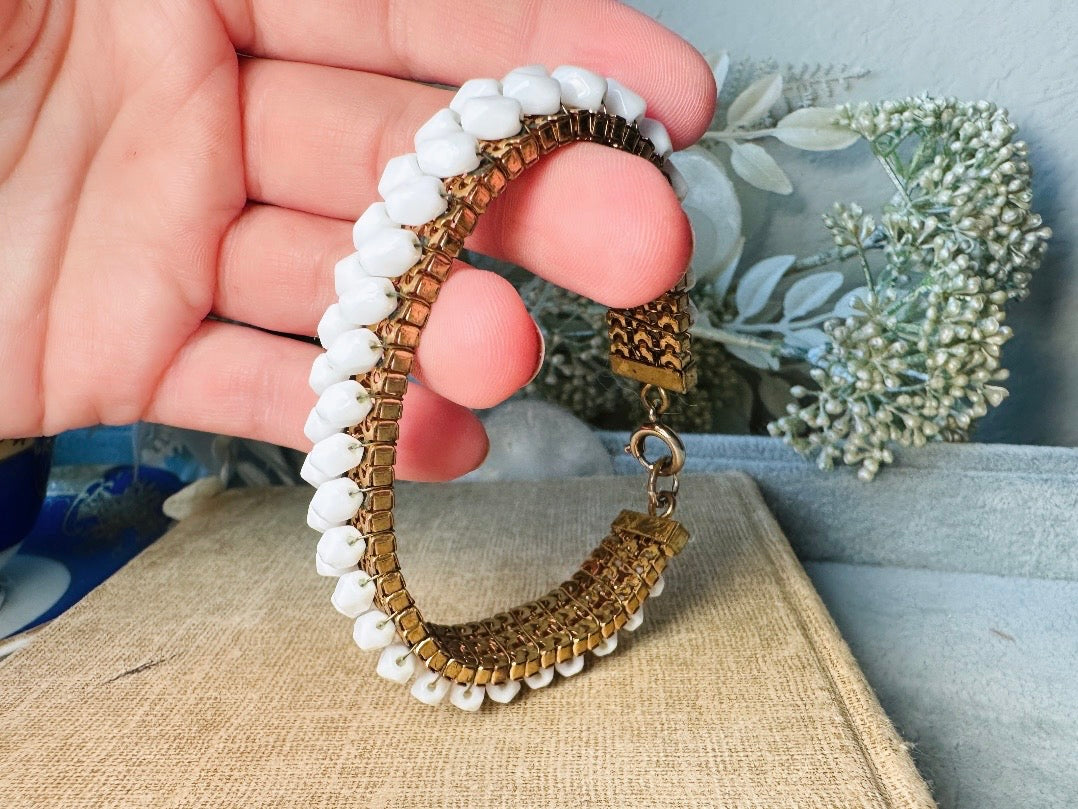 This beautiful white and gold 1960s vintage bracelet is so very pretty. Featuring triple strands of gold mesh chain with two strands of faceted milk glass crystals woven into the design. A simple spring ring closure brings this bracelet together. Easy to wear for everyday or would make a gorgeous bridal piece. A classic 1960s piece- in great vintage condition- please see all pics.
Dimensions: approximately 7.5" long, 0.5" wide.