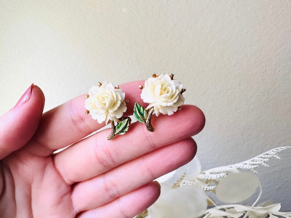 1950s Rose Earrings, Cream Celluloid Flower Earrings with Green and Gold Leaf Accents from Piggle and Pop held in hand