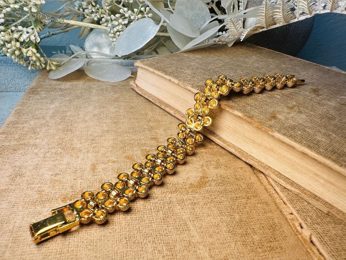 Gold bracelet on an open book with a decorative background
