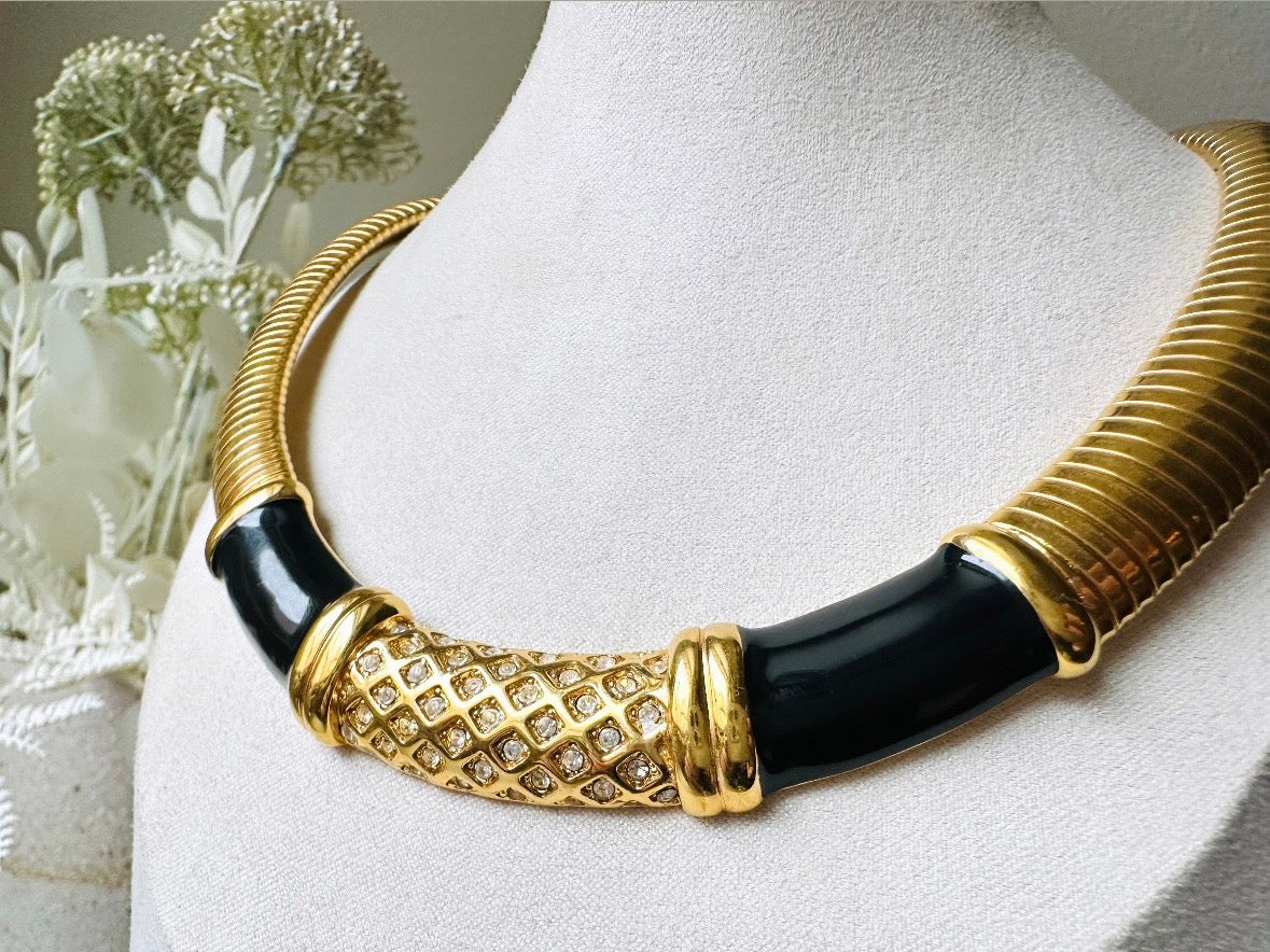 This vintage omega necklace is a stunning black and gold Monet designer vintage necklace. Featuring wide band snake chain and geometric segments of black enamel. This 1980s vintage rhinestone collar necklace has a fold over clasp and extender link. &nbsp;Excellent condition. This vintage designer necklace is high quality, weighty and well made. 
