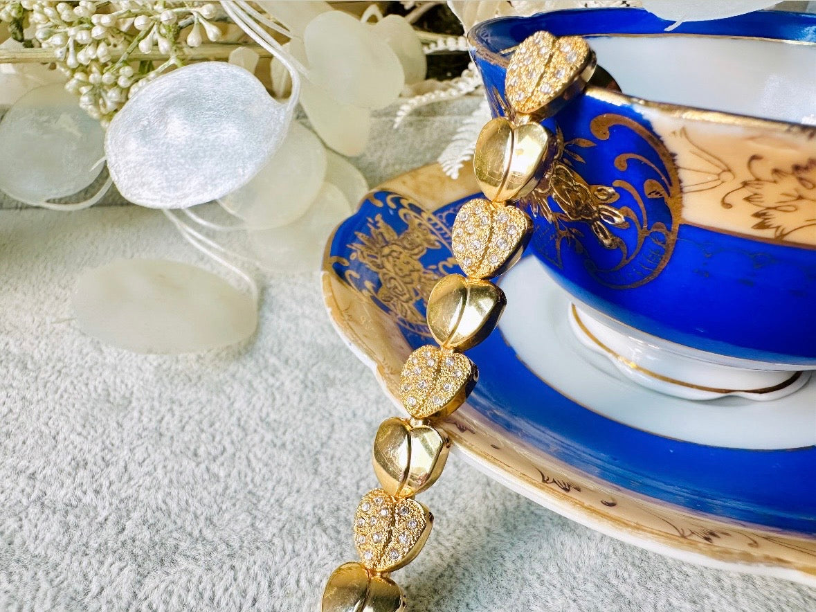 This sparkling rhinestone and gold heart bracelet is so darling. Featuring smooth gold hearts alternating with pave set rhinestone heart links. A lovely classic little bracelet.