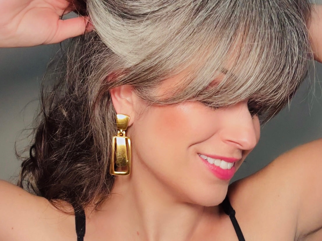 These Anne Klein vintage matte gold designer earrings are spectacular. Full of 1980s bold glamour, these clip ons have a satin gold finish and a geometric design. These vintage dangle earrings are bold and elegant, with curved square posts and rectangular drops with a cut out hollow border. These are big and incredibly well made in a satin matte gold finish. Clip on style, easy to wear and in great vintage condition. Highly sought after designer vintage. Modelde by Bethan Jayne