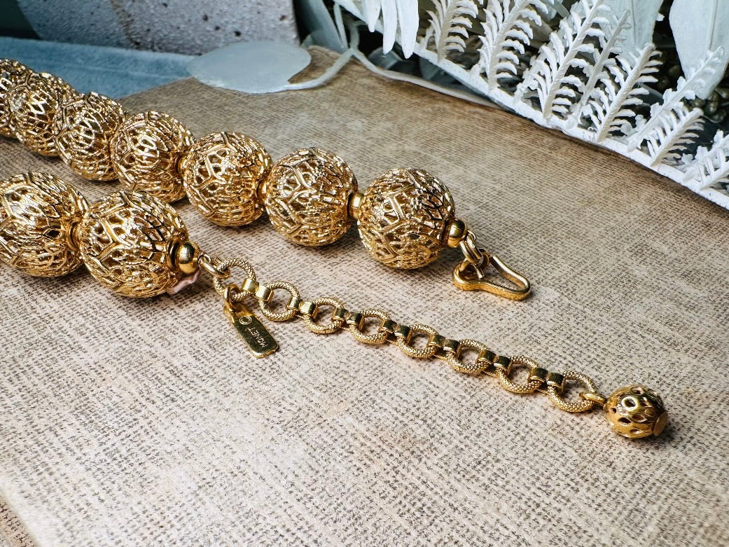 This chunky gold filigree vintage necklace is a timeless piece. Signed Monet- jewelry that is renowned for standing the test of time in both quality and style. This gold lace filigree necklace is composed of delicate and striking filigree beads with tiny gold spacers. Hook closure with beautiful gold extension chain and signature Monet hang tag. Excellent &nbsp;vintage condition- please see all pics.&nbsp;