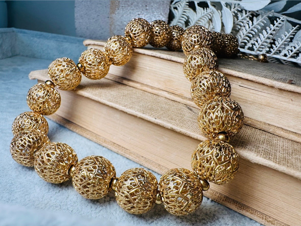 This chunky gold filigree vintage necklace is a timeless piece. Signed Monet- jewelry that is renowned for standing the test of time in both quality and style. This gold lace filigree necklace is composed of delicate and striking filigree beads with tiny gold spacers. Hook closure with beautiful gold extension chain and signature Monet hang tag. Excellent &nbsp;vintage condition- please see all pics.&nbsp;