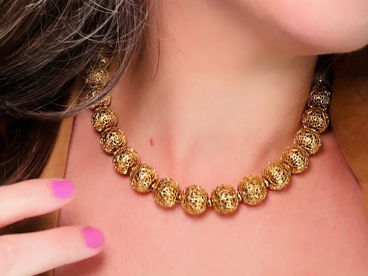 This chunky gold filigree vintage necklace is a timeless piece. Signed Monet- jewelry that is renowned for standing the test of time in both quality and style. This gold lace filigree necklace is composed of delicate and striking filigree beads with tiny gold spacers. Hook closure with beautiful gold extension chain and signature Monet hang tag. Excellent &nbsp;vintage condition- please see all pics.&nbsp;