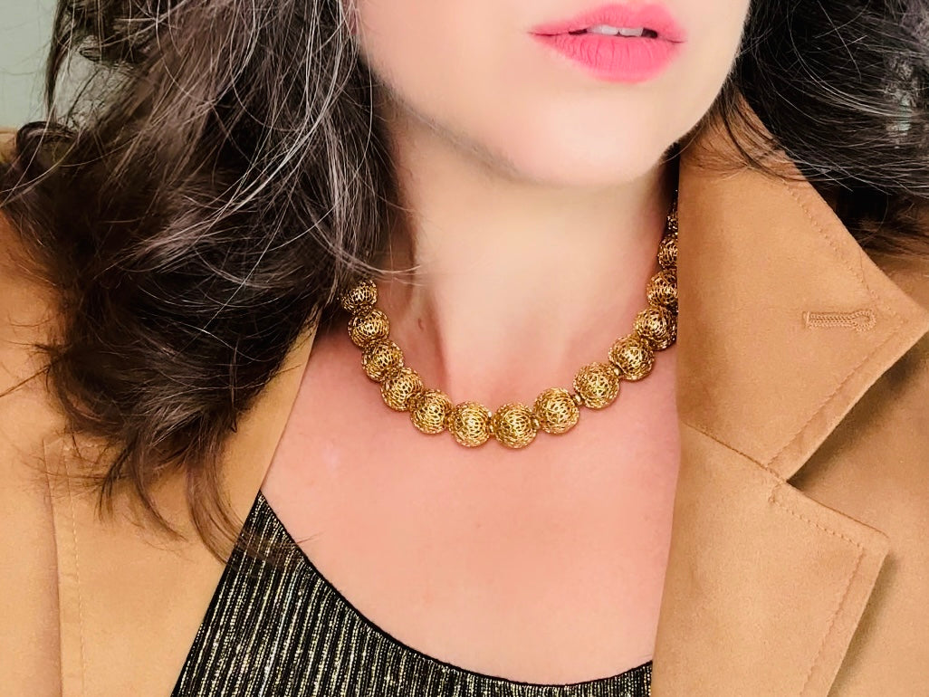 This chunky gold filigree vintage necklace is a timeless piece. Signed Monet- jewelry that is renowned for standing the test of time in both quality and style. This gold lace filigree necklace is composed of delicate and striking filigree beads with tiny gold spacers. Hook closure with beautiful gold extension chain and signature Monet hang tag. Excellent &nbsp;vintage condition- please see all pics.&nbsp;