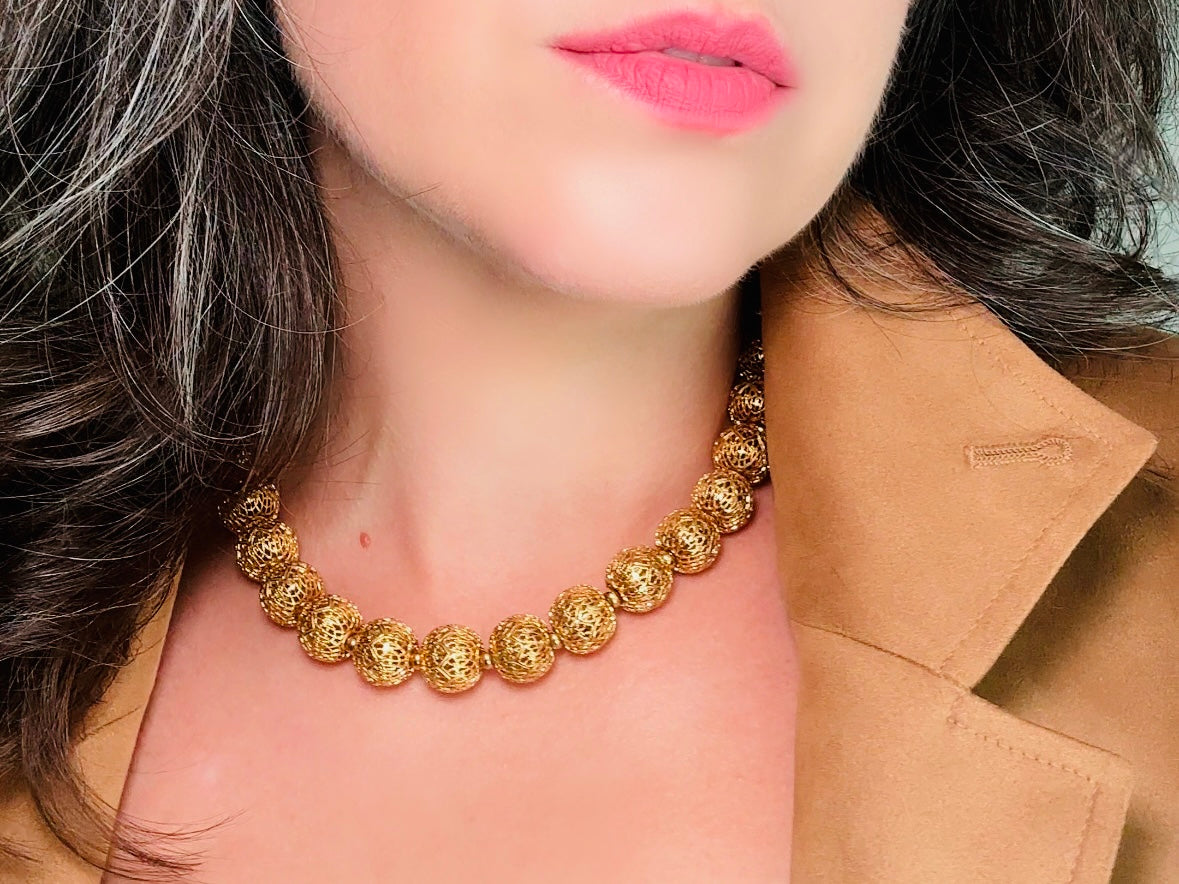 This chunky gold filigree vintage necklace is a timeless piece. Signed Monet- jewelry that is renowned for standing the test of time in both quality and style. This gold lace filigree necklace is composed of delicate and striking filigree beads with tiny gold spacers. Hook closure with beautiful gold extension chain and signature Monet hang tag. Excellent &nbsp;vintage condition- please see all pics.&nbsp;