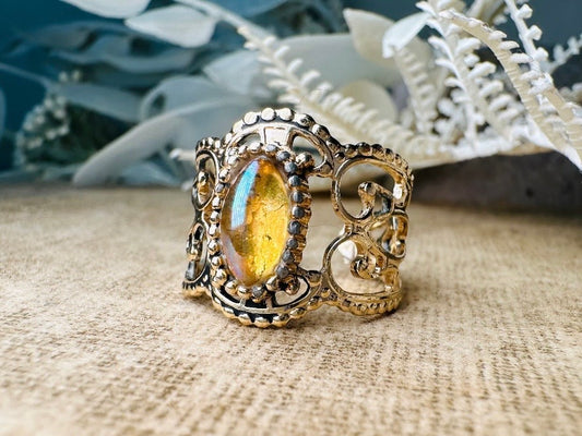 This 1970s Victorian revival vintage filigree ring is gorgeous. Featuring a faux fire opal cabochon stone set in a gold dotted bezel, the base of the ring is a beautiful open work lace filigree in an antique gold. High quality and strong filigree. Marked Sarah Coventry from 1970s. 