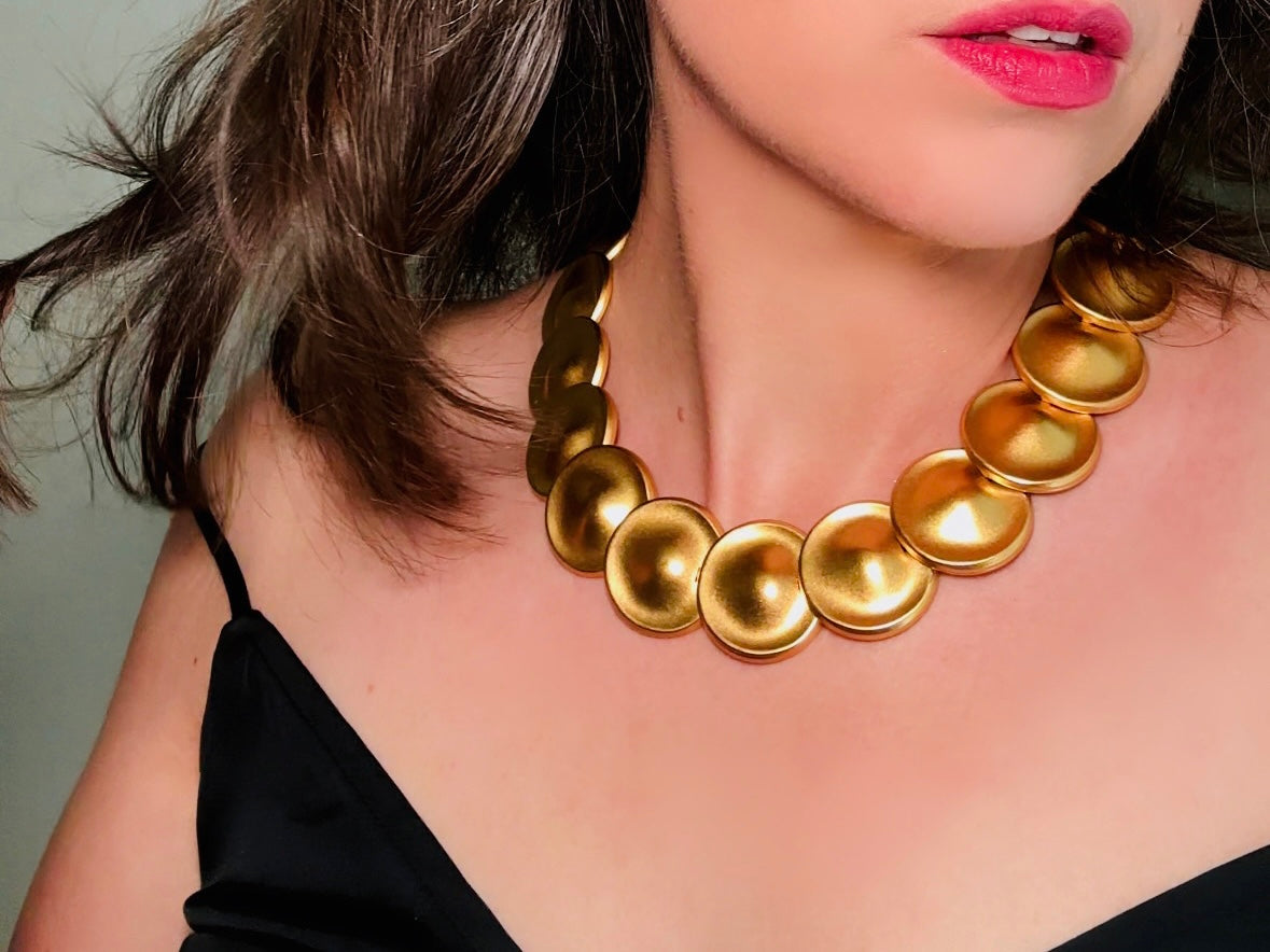 This vintage brushed gold Monet disc necklace is perfection. This vintage Cleopatra style choker is the height of 80s glamour, featuring stunning articulated satin gold discs. This necklace is so flattering on, laying perfectly on the collarbones. Adjustable hook closure with gold chain extender. Monet is renowned and well loved for beautiful jewelry that has stood the test of time. 