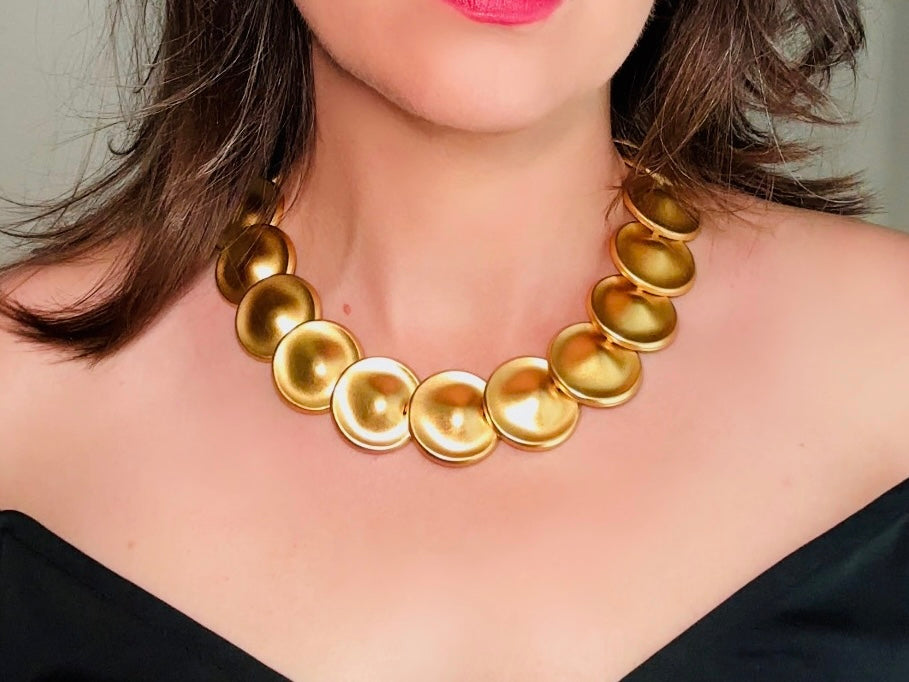 This vintage brushed gold Monet disc necklace is perfection. This vintage Cleopatra style choker is the height of 80s glamour, featuring stunning articulated satin gold discs. This necklace is so flattering on, laying perfectly on the collarbones. Adjustable hook closure with gold chain extender. Monet is renowned and well loved for beautiful jewelry that has stood the test of time. 