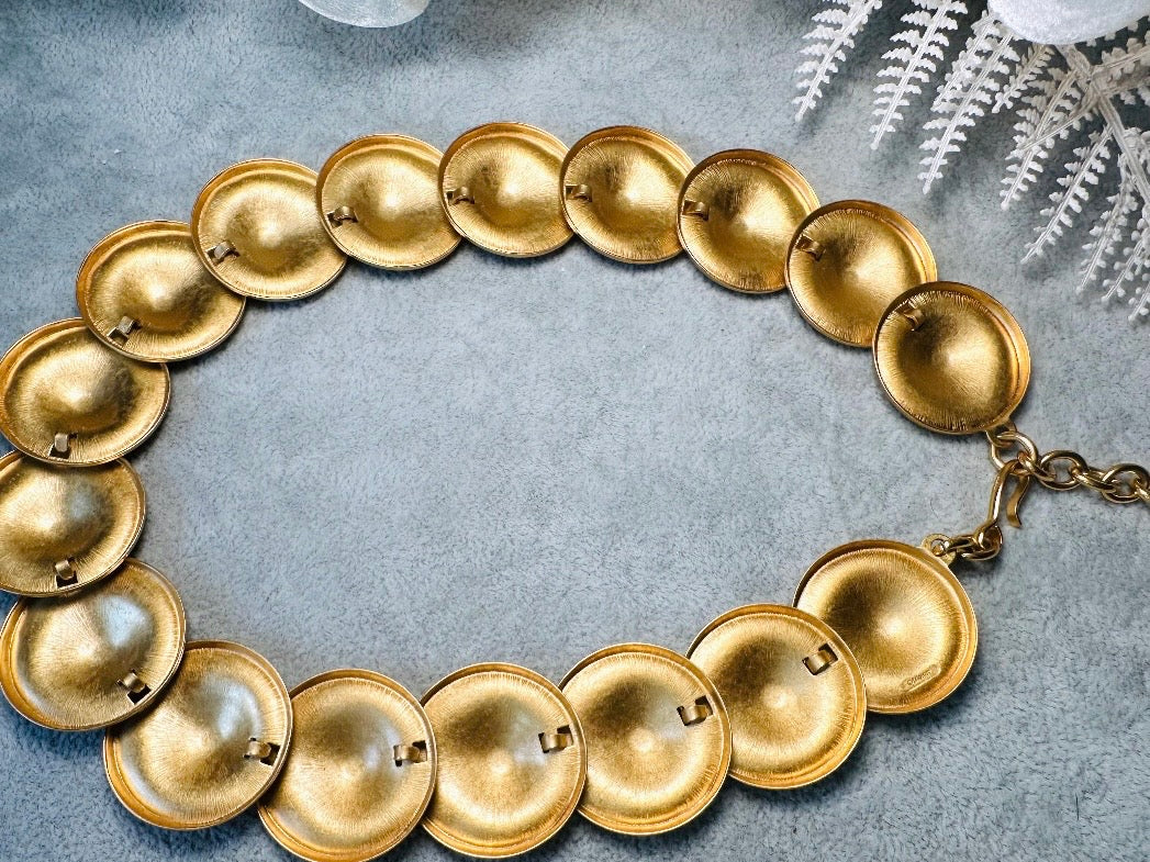 This vintage brushed gold Monet disc necklace is perfection. This vintage Cleopatra style choker is the height of 80s glamour, featuring stunning articulated satin gold discs. This necklace is so flattering on, laying perfectly on the collarbones. Adjustable hook closure with gold chain extender. Monet is renowned and well loved for beautiful jewelry that has stood the test of time. 