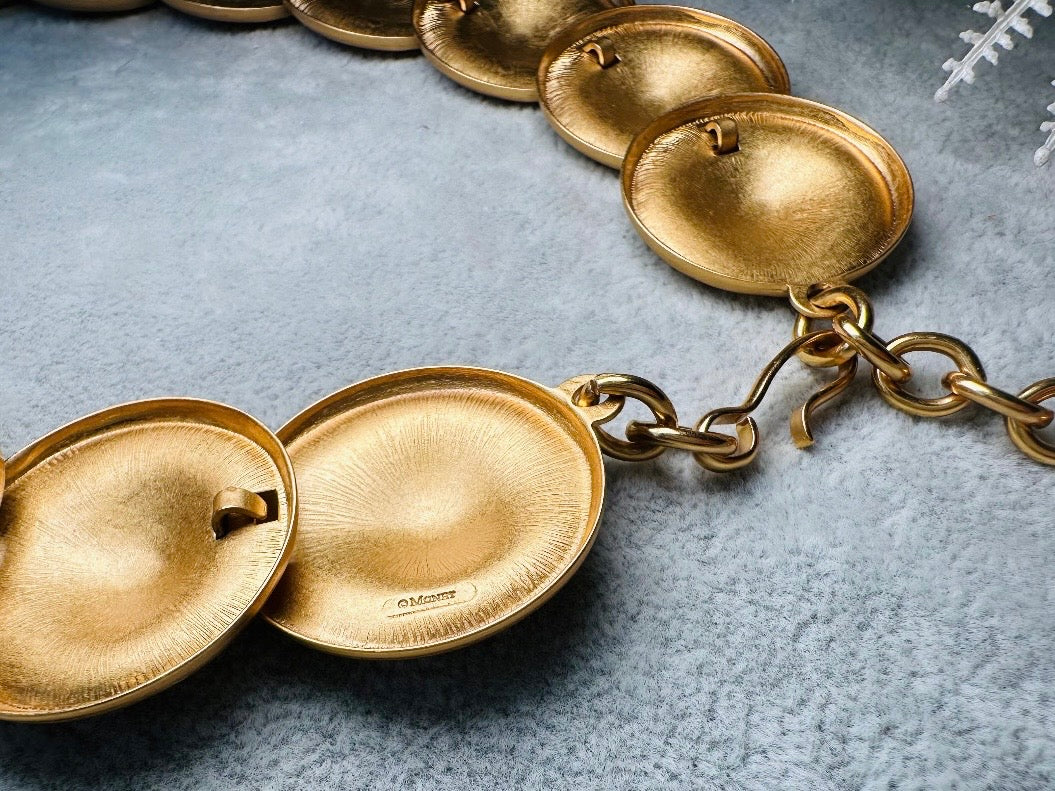 This vintage brushed gold Monet disc necklace is perfection. This vintage Cleopatra style choker is the height of 80s glamour, featuring stunning articulated satin gold discs. This necklace is so flattering on, laying perfectly on the collarbones. Adjustable hook closure with gold chain extender. Monet is renowned and well loved for beautiful jewelry that has stood the test of time. 