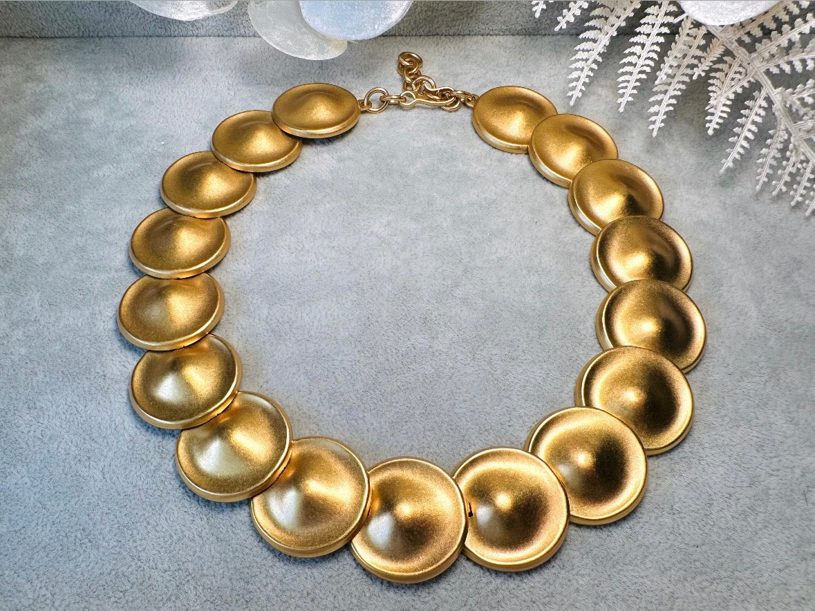 This vintage brushed gold Monet disc necklace is perfection. This vintage Cleopatra style choker is the height of 80s glamour, featuring stunning articulated satin gold discs. This necklace is so flattering on, laying perfectly on the collarbones. Adjustable hook closure with gold chain extender. Monet is renowned and well loved for beautiful jewelry that has stood the test of time. 