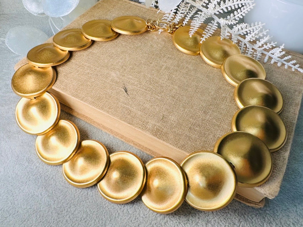 This vintage brushed gold Monet disc necklace is perfection. This vintage Cleopatra style choker is the height of 80s glamour, featuring stunning articulated satin gold discs. This necklace is so flattering on, laying perfectly on the collarbones. Adjustable hook closure with gold chain extender. Monet is renowned and well loved for beautiful jewelry that has stood the test of time. 