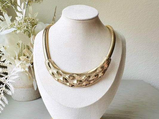 This gold omega necklace is a Park Lane signed designer vintage choker necklace from the 1980s. Featuring wide band gold snake chain with a textured raised geometric crescent bar, this gold collar necklace is bold and beautiful. In excellent vintage condition, signed Park Lane on back.