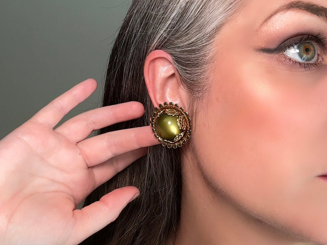 These gorgeous 1950s moonglow Caroline Emmons vintage earrings are stunning. Featuring glowing avocado green lucite cabochons set in a lacey gold open work bezel. These authentic 50s vintage earrings are gold tone base clip on style, signed on back. Their large size, incredible details and spectacular moon glow effect make them a unique collector's pair. Great vintage condition, no major flaws to note - please see pics. Such a stunning statement pair! Beautiful cocktail pair for the holidays.