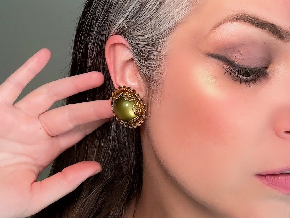 These gorgeous 1950s moonglow Caroline Emmons vintage earrings are stunning. Featuring glowing avocado green lucite cabochons set in a lacey gold open work bezel. These authentic 50s vintage earrings are gold tone base clip on style, signed on back. Their large size, incredible details and spectacular moon glow effect make them a unique collector's pair. Great vintage condition, no major flaws to note - please see pics. Such a stunning statement pair! Beautiful cocktail pair for the holidays.