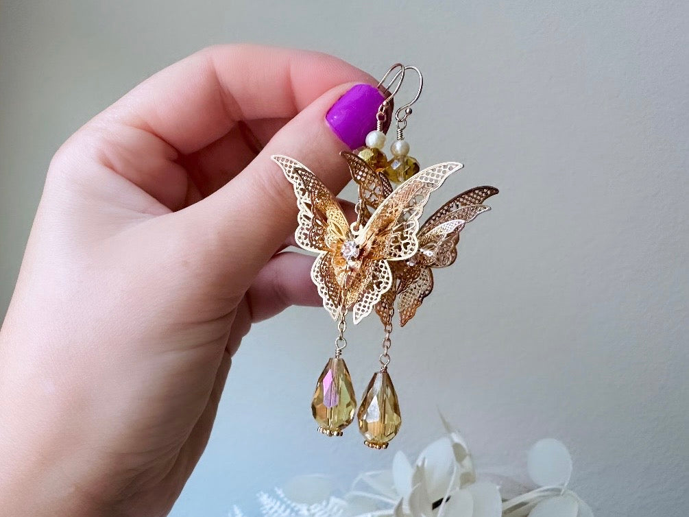 Handmade Golden Butterfly Earrings, 14kt Gold Crystal and Pearl Faerie Wedding Earrings from Piggle and Pop Original  held in hand