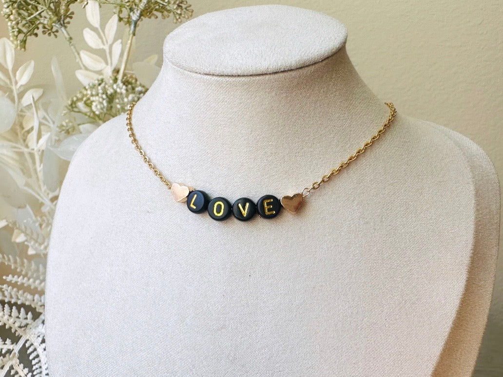 Handmade Love Beaded Necklace, 18k Chain Black and Gold Heart  on display bust