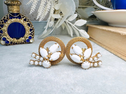 These vintage milk glass earrings are absolutely beautiful. I have never seen a design quite this interesting. Featuring a gold mesh arc with prong set faceted milk glass in marquis and round shapes, such an stunning silhouette. These are secure clip on earrings from the 1950's and are in great vintage condition- no missing stones- slight wear from age- please see pics. A truly unique and show-stopping pair.