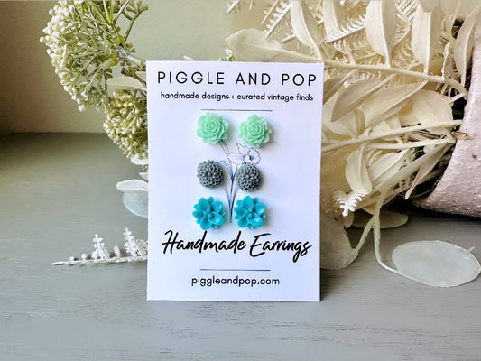 This listing is for three lovely pairs of handmade resin flower earrings. Mint open roses, tiny grey dahlias and teal lotuses are paired up in a pretty gift set. These semi- glossy floral earrings are mounted on hypoallergenic surgical steel posts with butterfly backs. Dressed up or down, they are perfect for any occasion
