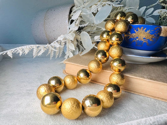 This vintage 1980s Napier chunky gold ball statement necklace is stunning. This high end bold vintage choker features alternating matte hammered gold balls and shiny smooth gold beads. Signed NAPIER on hook clasp. Absolutely classic necklace! Minimal wear in great vintage condition. Napier is renowned for beautiful jewelry that has stood the test of time. Classic and a true staple for your jewelry box.

Dimensions: &nbsp;beads are approximately 0.7" and necklace is 21" max- adjustable with hook closure. Ple