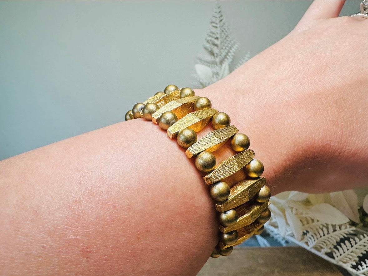 This bold 1970s vintage gold bracelet is so unique- featuring brushed gold bars and smooth polished gold beads. This chunky gold bracelet is timeless and would pair well with a variety of other pieces. &nbsp;An unsigned one of a kind bracelet and perfect jewelry gift for the vintage lover. Structural geometric pieces are currently trending. &nbsp;In great vintage condition, some very minor gold wear on hinge clip- please view all pics.