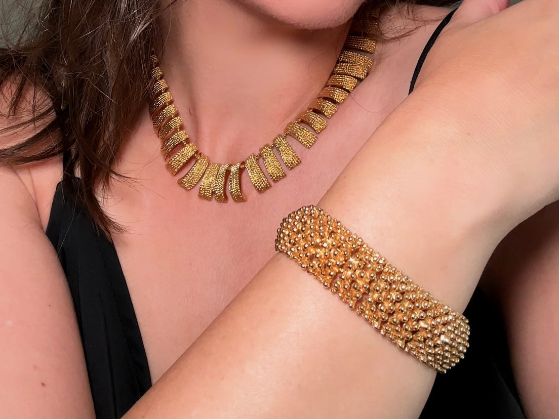 This vintage articulated chunky gold panel bracelet is a showstopper. This signed SC bracelet features articulated gold plated panels with a raised stipple texture throughout. Incredibly well made an in excellent vintage condition. Fastens with a fold over hinge clasp and looks incredible on its own or paired with others for a sensational stack. No flaws to note, please see all pics, from 1973.

Dimensions: 7.75" long, 0.75" wide. Fold over clasp closure.