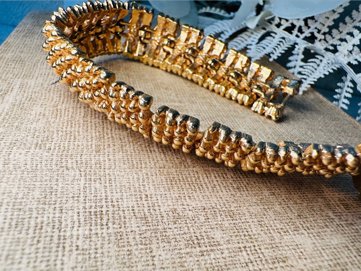This vintage articulated chunky gold panel bracelet is a showstopper. This signed SC bracelet features articulated gold plated panels with a raised stipple texture throughout. Incredibly well made an in excellent vintage condition. Fastens with a fold over hinge clasp and looks incredible on its own or paired with others for a sensational stack. No flaws to note, please see all pics, from 1973.

Dimensions: 7.75" long, 0.75" wide. Fold over clasp closure.