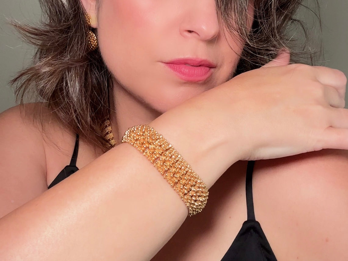 This vintage articulated chunky gold panel bracelet is a showstopper. This signed SC bracelet features articulated gold plated panels with a raised stipple texture throughout. Incredibly well made an in excellent vintage condition. Fastens with a fold over hinge clasp and looks incredible on its own or paired with others for a sensational stack. No flaws to note, please see all pics, from 1973.

Dimensions: 7.75" long, 0.75" wide. Fold over clasp closure.