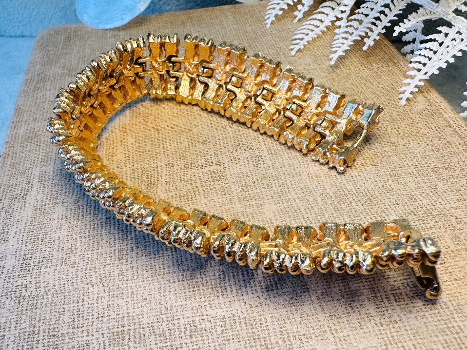 This vintage articulated chunky gold panel bracelet is a showstopper. This signed SC bracelet features articulated gold plated panels with a raised stipple texture throughout. Incredibly well made an in excellent vintage condition. Fastens with a fold over hinge clasp and looks incredible on its own or paired with others for a sensational stack. No flaws to note, please see all pics, from 1973.

Dimensions: 7.75" long, 0.75" wide. Fold over clasp closure.