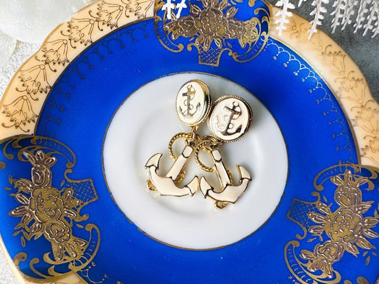 These cream and gold vintage anchor earrings are a gorgeous pair of nautical statement earrings by Park Lane. Featuring dreamy cream enamel and gold anchor and rope accent details, these pierced style dangle earrings are a classic and perfect for summer! 