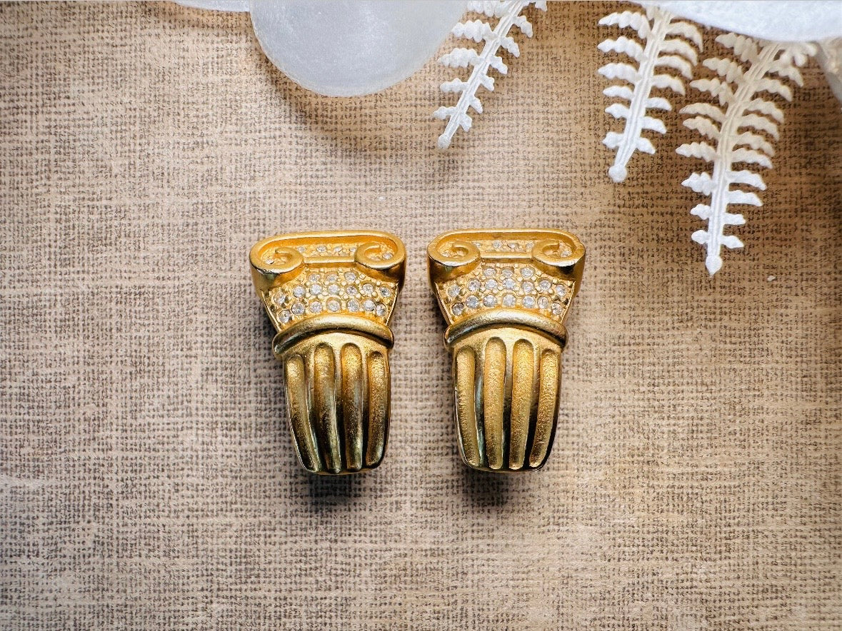 These vintage gold Carolee Roman column earrings are an incredible pair of bold neoclassical earrings. Featuring a matte gold finish, these clip on style sculptural earrings are accented with tiny pave set rhinestones. An incredible pair of signed designer earrings from the 1980s. A truly striking vintage treasure. Please view all pics and let me know if you have any questions at all!