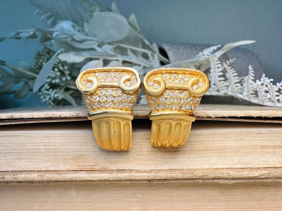 These vintage gold Carolee Roman column earrings from Piggle and Pop are an incredible pair of bold neoclassical earrings. Featuring a matte gold finish, these clip on style sculptural earrings are accented with tiny pave set rhinestones. An incredible pair of signed designer earrings from the 1980s. A truly striking vintage treasure. Please view all pics and let me know if you have any questions at all!