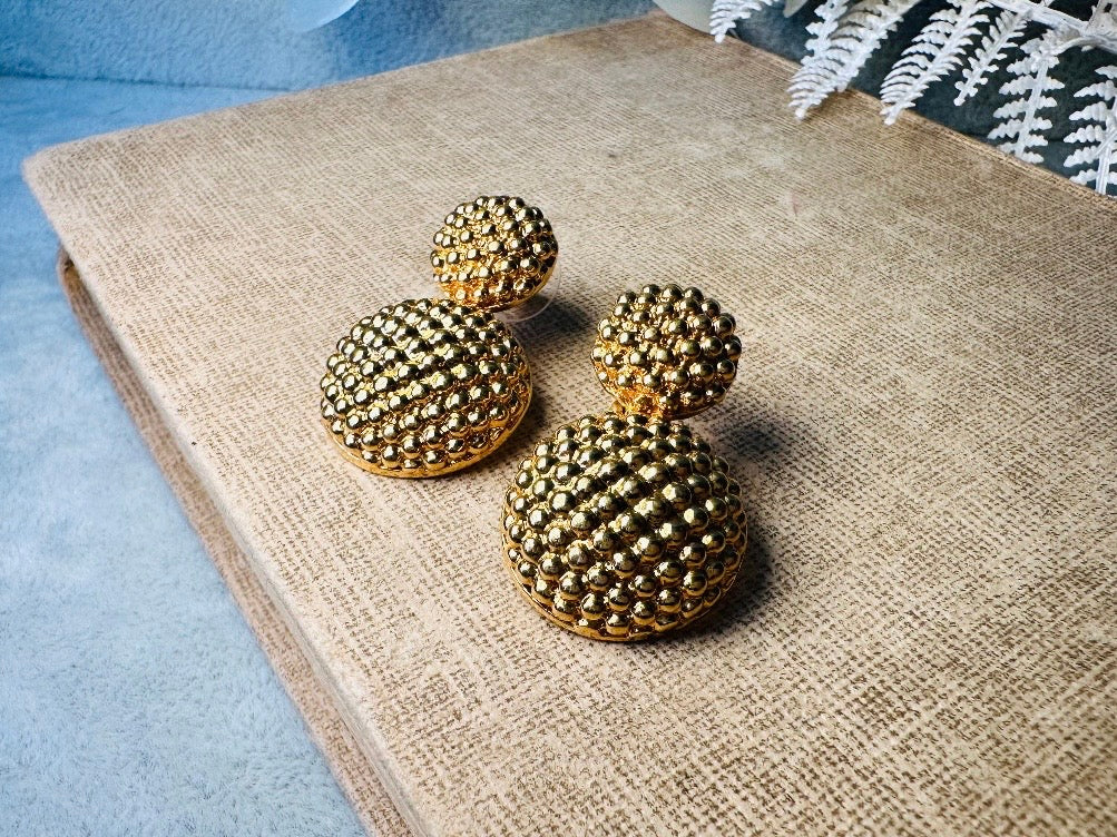 These vintage gold statement earrings are absolutely fabulous! Gold tone double dome drop earrings &nbsp;are chock full of interesting details. These earrings feature 2 large dome shaped gold components with a dotted "raspberry" texture- just so stunning! These earrings are such a classic 80s pair- bold and dramatic! In great vintage condition -no major flaws to note- please see pics. Signed Avon- pierced style!