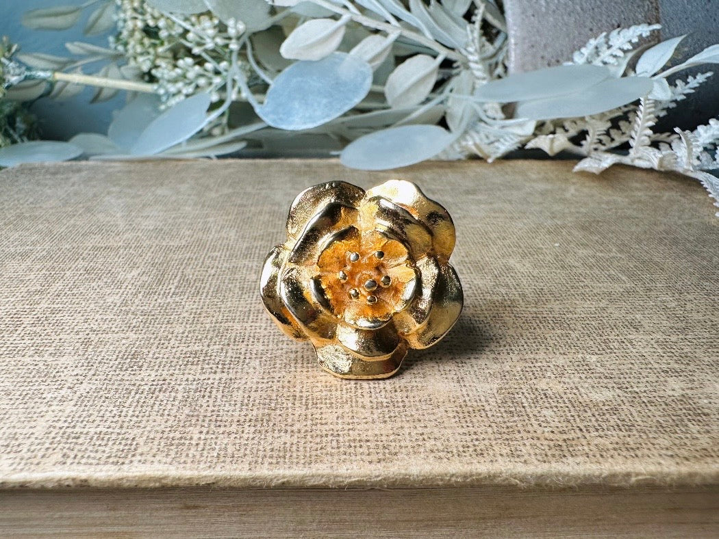 This bold vintage gold magnolia ring from Piggle and Pop is an incredible statement piece. Featuring a chunky gold base and blooming oversized magnolia, this sculptural flower ring is a stunning cocktail ring. Pair is with others for a fun maximalist look or let it shine on its own. This ring is stamped 8 for its size but is unmarked to its maker. A solid well made piece in excellent vintage condition.

Dimensions: fitted US size 8
