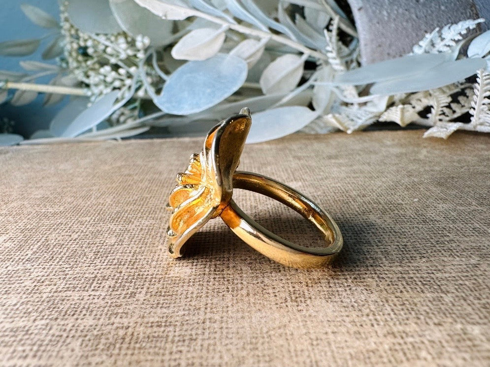 This bold vintage gold magnolia ring from Piggle and Pop is an incredible statement piece. Featuring a chunky gold base and blooming oversized magnolia, this sculptural flower ring is a stunning cocktail ring. Pair is with others for a fun maximalist look or let it shine on its own. This ring is stamped 8 for its size but is unmarked to its maker. A solid well made piece in excellent vintage condition.

Dimensions: fitted US size 8