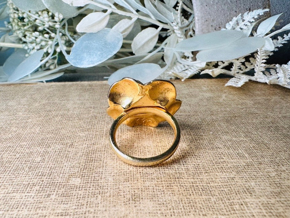 This bold vintage gold magnolia ring from Piggle and Pop is an incredible statement piece. Featuring a chunky gold base and blooming oversized magnolia, this sculptural flower ring is a stunning cocktail ring. Pair is with others for a fun maximalist look or let it shine on its own. This ring is stamped 8 for its size but is unmarked to its maker. A solid well made piece in excellent vintage condition.

Dimensions: fitted US size 8