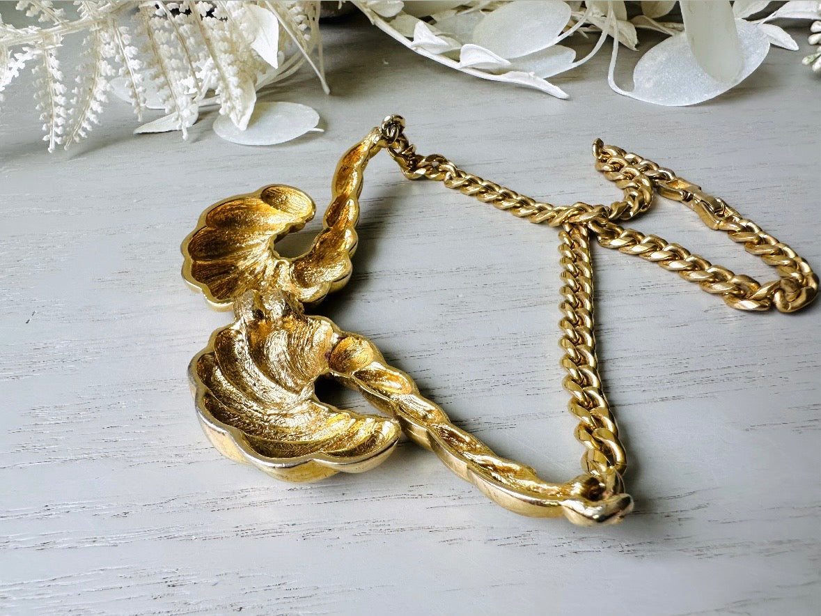 This 1970s vintage gold necklace is such a striking and unique piece. Featuring gold curb chain and a striking centerpiece of two textured gold horns. Full of vintage flair, this centerpiece is dimensional and stunning. This choker necklace is so flattering on and the perfect collar length. 