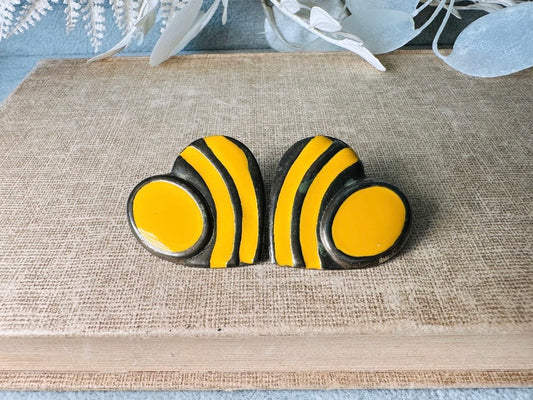 These golden yellow and antique silver heart earrings are such a retro vibe. Oversized metal hearts with mustard yellow enamel accents. Pierced post style. Really interesting pattern and a great size. Great vintage condition, minor wear from age. A fun and funky pair for the vintage lover.

Dimensions: about 1.5" See pics for visual size reference