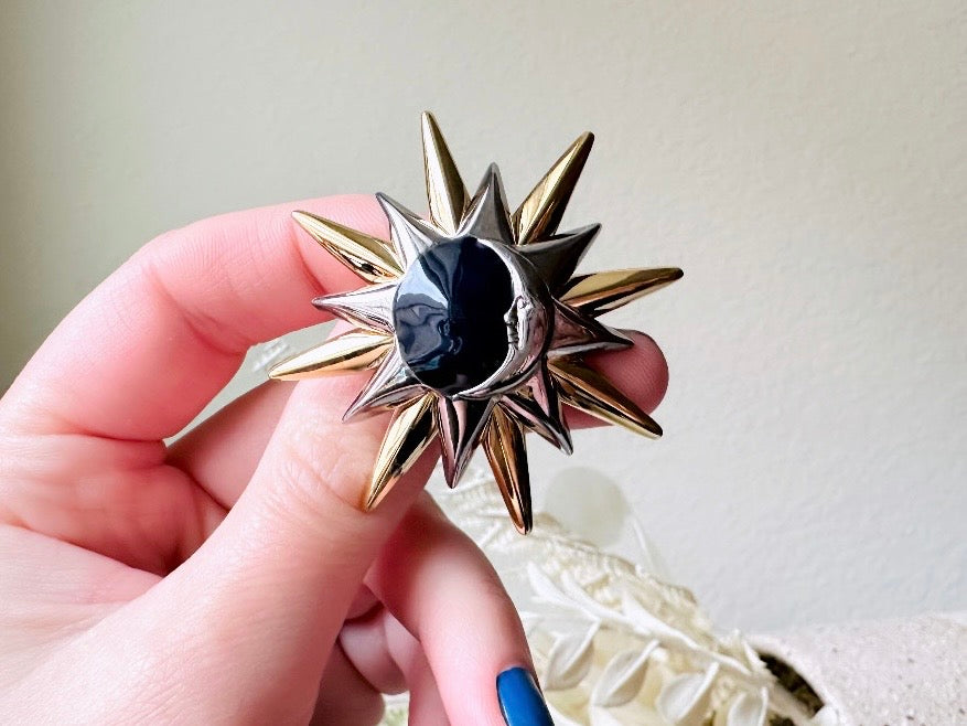 This is a vintage Liz Claiborne moon and starburst brooch from the 1980s. In excellent condition, this pin features a silver and gold starburst with a silver crescent moon on top of black circular enamel inlay. High quality designer signed brooch. No flaws to note, this vintage brooch has a fully working pin and lock, in great condition.