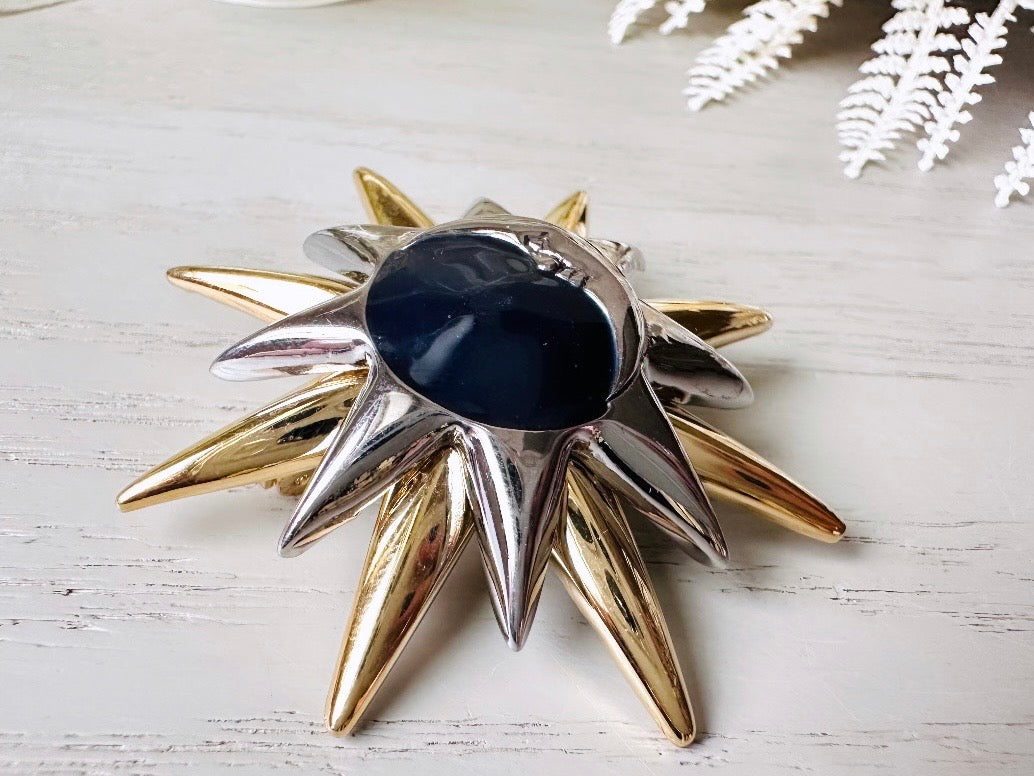 This is a vintage Liz Claiborne moon and starburst brooch from the 1980s. In excellent condition, this pin features a silver and gold starburst with a silver crescent moon on top of black circular enamel inlay. High quality designer signed brooch. No flaws to note, this vintage brooch has a fully working pin and lock, in great condition.